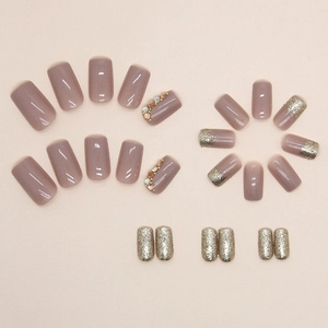 Medium square press-on nails with sparkling gold glitter, pearls, and mauve shades