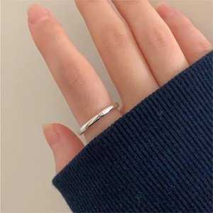 Close-up of minimalist 925 silver smiley face ring on finger with glossy finish