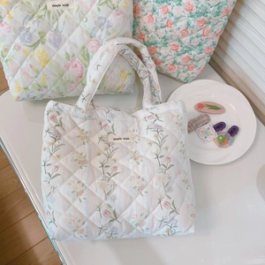 Close-up of quilted floral tote bags with simple wish label in a cozy indoor setting