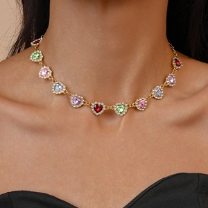 Collier doré élégant avec strass multicolores en forme de cœur porté par un mannequin