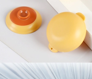 Detail view of yellow ABS dollhouse miniature casserole pot with an orange lid handle