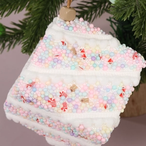 Detailaufnahme von Makronenfarbenem Schaumstoff-Kuchenschmuck mit Miniatur-Weihnachtsdeko