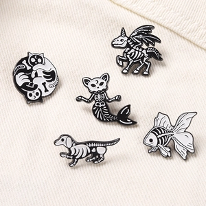 Détail de cinq pin's créatifs en émail de squelettes d'animaux dont chat et licorne sur coton