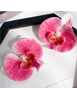 Detail of gradient pink orchid hair clips with pearls on a white and black background