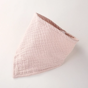 Détail du bavoir pour bébé en mousseline de coton rose clair avec bouton-pression de fixation