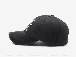 Side view detail of washed black denim baseball cap with white 3D letter embroidery