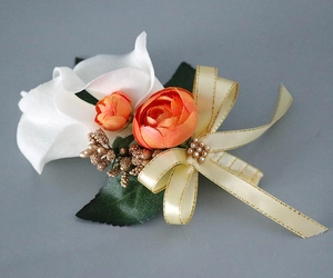 Detail of bridal boutonniere featuring white calla lily, orange roses and satin bow