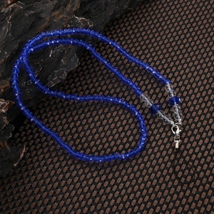Blue and transparent crystal bead phone lanyard with metal clasp on a textured rock surface
