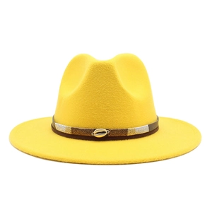 Detail of yellow wool fedora hat with brown leather band and golden shell accessory