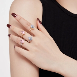 Model wearing pear-cut cubic zirconia rings in pink and white with pavé bands
