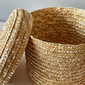 Handwoven round straw gift box with lid showing natural fiber textures for home storage