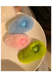 Detailed view of three candy-colored plush rabbit fur hair clips with cute heart decorations