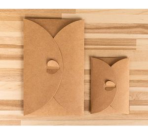 Two sizes of vintage kraft paper envelopes on a rustic wooden table background