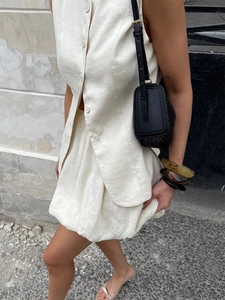 Détail de la texture en lin blanc crème sur l'ensemble gilet et jupe boule