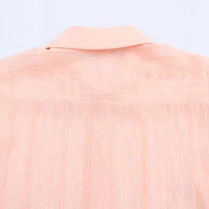 Detalle del cuello de camisa naranja claro con textura de tejido vertical de calidad