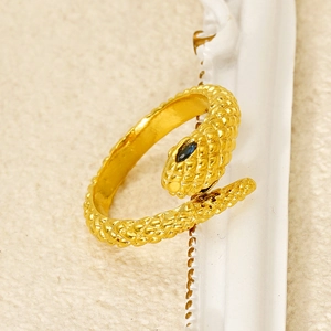 Golden snake ring with diamond-set eyes and detailed scales in a minimalist style