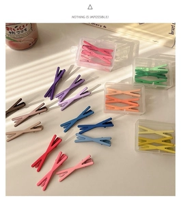 Detail of matte Morandi-colored cross hair clips in a clear storage box and set layout