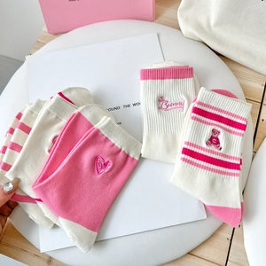 Detailed flat lay of pink striped cotton socks with cute bear and heart embroidery