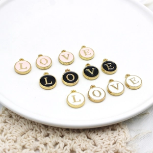 Macro detail of round alloy enamel LOVE letter charms for DIY jewelry making