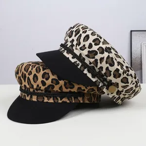 Detail of leopard print baker boy hats with decorative black ropes and metal buttons