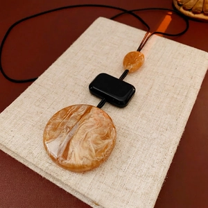 Minimalist geometric sweater necklace with amber texture marble and black pendant