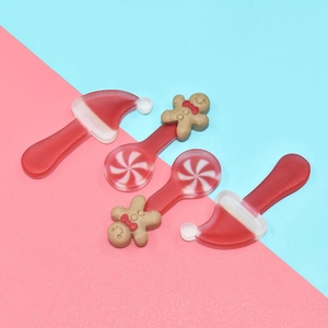 Flat lay of resin Christmas hats and gingerbread man lollipop charms for DIY crafts