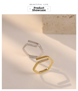 Close-up of geometric hexagonal open rings with white rhinestones in gold and silver