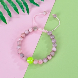 Dettaglio del bracciale in pietra zebra rosa con perla a forma di pallina da tennis