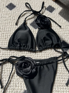 Detailed view of black bikini with 3D handmade roses and side-tie adjustable strings