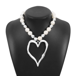 Exaggerated beaded necklace with large pearls and hollow fluid heart pendant detail