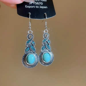 Detail of silver leaf hollow fringe earrings with oval turquoise stone and blue rhinestones