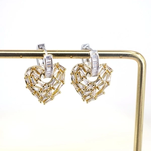 Macro shot of gold and silver heart earrings with micro-pave cubic zirconia settings