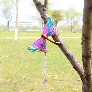 Close-up of a colorful dragonfly garden pendant with crystal beads on a tree branch