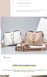 Detail of wide lettered shoulder strap and gold hardware on minimalist bucket bag