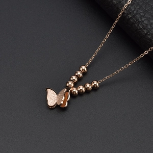 Elegant rose gold butterfly necklace with matte finish and shiny beads on black leather