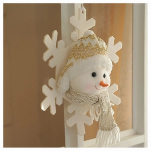 Detail of plush snowman ornament with gold knit hat and snowflake base for tree decor