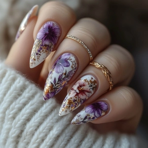 Faux ongles amande à motifs floraux violets, feuilles d'or et mise en scène élégante