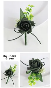 Close-up of dark green PE rose boutonniere with decorative ribbon and small white flowers