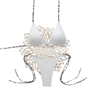 White bikini set with leopard print straps on a flat lay display with flower mat