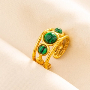 Detail of an adjustable 18K gold ring featuring malachite stones and a twisted band
