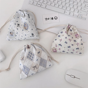 Detailed view of three pastel drawstring pouches with bear and floral patterns
