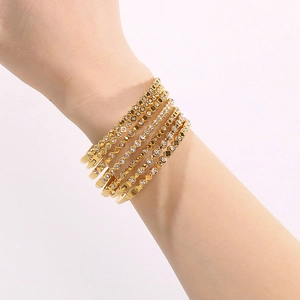 Dettaglio di bracciali a cerchio in acciaio inossidabile placcato oro 18K con zirconi.