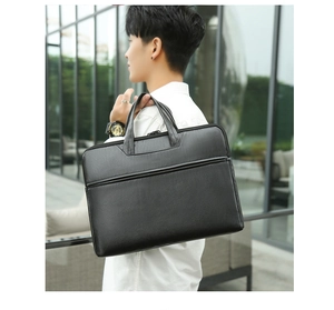 Detail shot of a professional black leather laptop briefcase with reinforced top handles