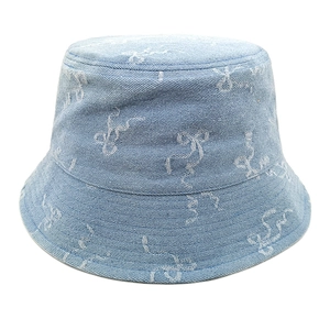 Détail d'un chapeau bob en denim bleu clair avec motifs de nœuds blancs et coutures soignées