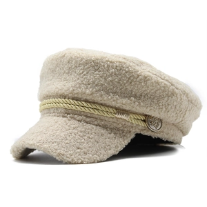 Close-up of fluffy cream faux shearling texture with twisted rope and vintage metal button