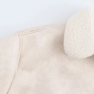 Detailed close-up of faux suede fabric and white faux shearling collar on a beige jacket
