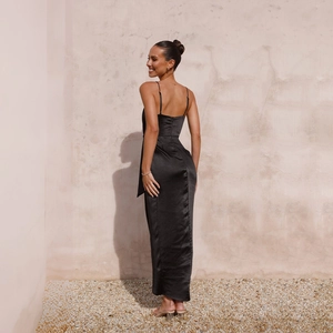 Détail de la robe nuisette en satin noir montrant la coupe dos nu et la texture soyeuse