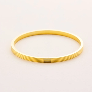 Detailed view of golden titanium steel bracelet with parallel grooves and side engraving