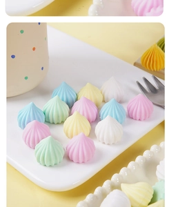Macro shot of colorful spiral resin candy miniatures on a white ceramic plate
