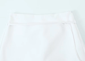 Detail view of white skirt waistband with concealed zipper and premium fabric texture